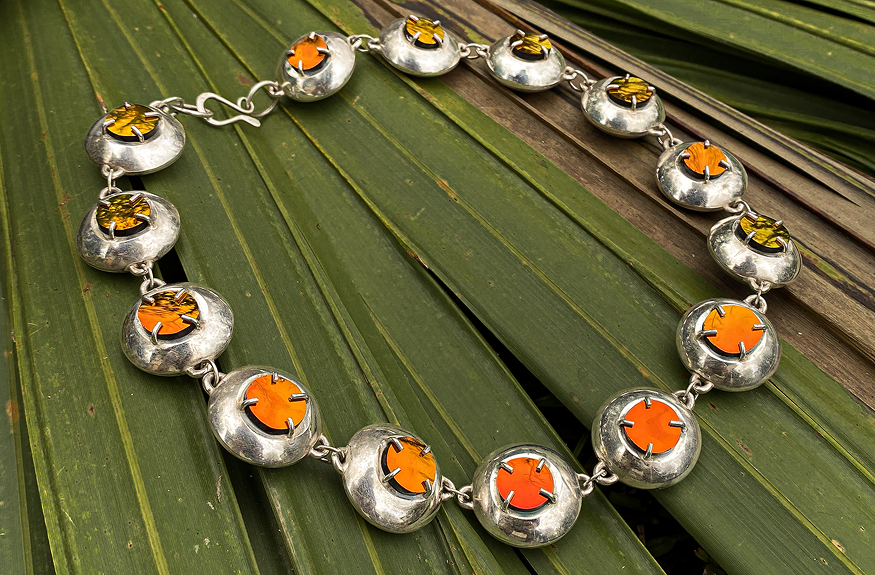 Sunglass Necklace arranged in a circle on palm leaves
